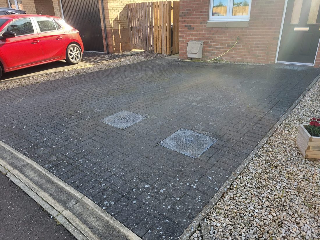 Driveway before cleaning, dirt and weeds in the paving
